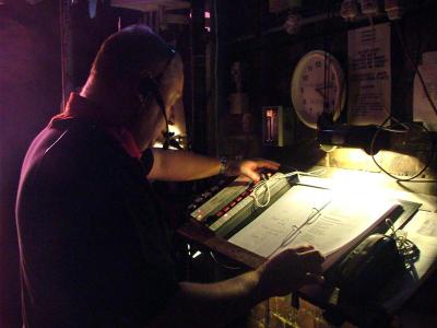 a man in red shirt, looking over a script on a desk